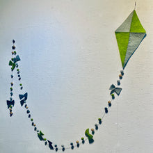 Afbeelding in Gallery-weergave laden, Vlieger slinger van vilt in de kleuren groen en blauw. Deze slinger hangt aan een muur. Hij is 3 meter lang. Aan de lijn hangen vilten balletjes en strikjes in de kleuren groen, lichtblauw, turquoise en beige. 
